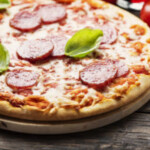 Italian pizza with salami and tomato, rustic stlye and selective focus image